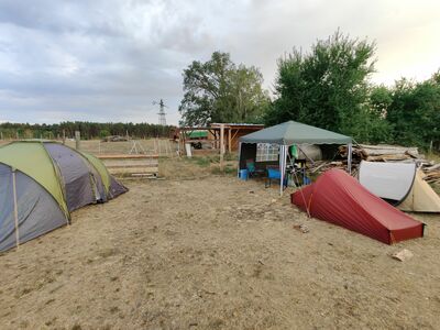 Einige aufgebaute Zelte sind zu sehen, dahinter ein Pavillon.