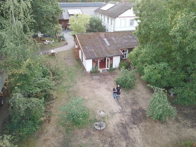 In einem Gebäudeteil wurde gekocht. Hier sieht man das Gebäude von oben, zwei Drohnenpiloten stehen vor dem Haus.