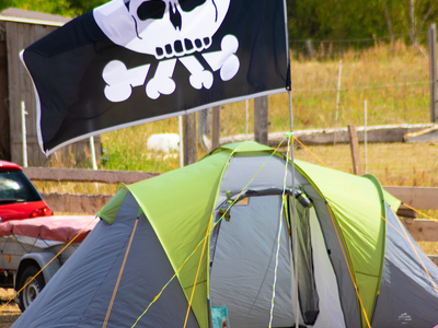 Grün-Graues Zelt, davor eine Pesthörnchen-Flagge.