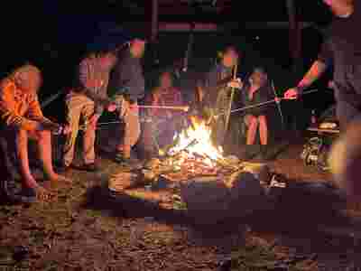 Einige Personen rösten Marshmallows über dem Feuer.
