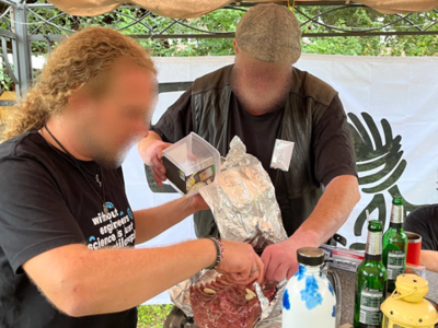 Zwei Personen bereiten einen Braten in Alufolie vor.