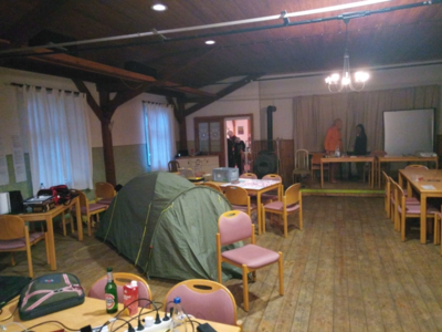Wegen Regen in der letzten Nacht bauen einige Personen ihr Zelt im Veranstaltungsraum auf.
