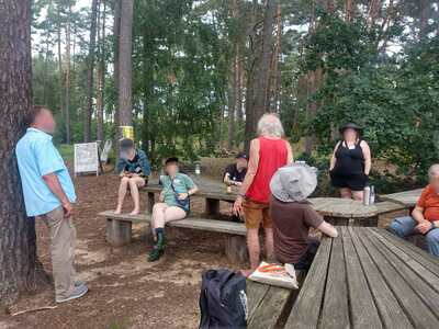 Eine Gruppe von Personen am Waldrand beim Besuch des ehemaligen Endlagers Gorleben.