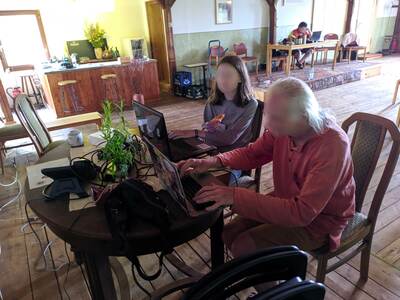 Zwei Personen sitzen am Laptop.