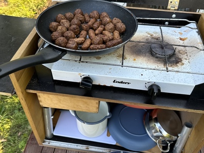 Vegane Buletten braten auf einem Gasherd im Freien.