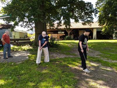 Drei Personen spielen Crossgolf.