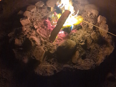 Lagerfeuer, Personen halten Marshmallows am Stock ins Feuer.
