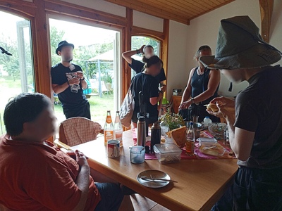 Personen in der Küche beim Gespräch und Frühstück.